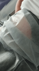 Resting in a medical bed with vitals being monitored nearby.