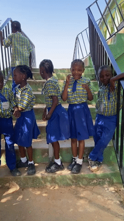 School children gather in uniforms on stairs in Nigeria