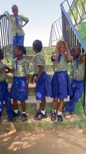 School children gather in uniforms on stairs in Nigeria