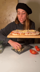 Woman makes homemade pizza while cat plays in Bar, Montenegro