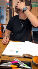 Young artist sketches at wooden table in Buenos Aires