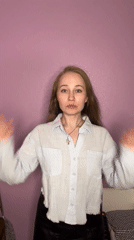 Woman poses against purple wall in Saint Petersburg photoshoot