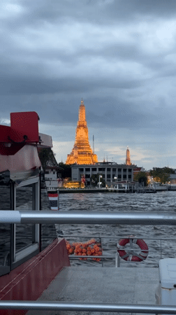 Illuminated Wat Arun temple viewed from Chao Phraya River boat