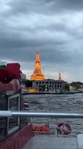 Illuminated Wat Arun temple viewed from Chao Phraya River boat