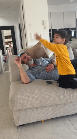 Man with toy rests on couch in Luxembourg home