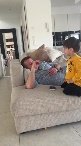 Man with toy rests on couch in Luxembourg home