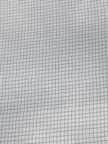The video shows a close-up, static shot of a white surface with a gray grid pattern. The grid lines are thin and appear to be slightly wavy, suggesting the surface might be fabric or a similar flexible material. There are no people, objects, or actions visible in the video. The lighting is uniform, casting no harsh shadows. The overall impression is one of a textured background or a simple pattern.