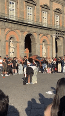 Skateboarder performs tricks for crowd in Naples plaza
