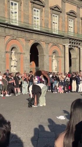 Skateboarder performs tricks for crowd in Naples plaza