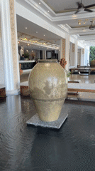 Cracked vase observed in rippling water feature, Vietnam resort