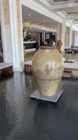 Cracked vase observed in rippling water feature, Vietnam resort
