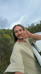 Man makes rock gesture by white car in Montenegro