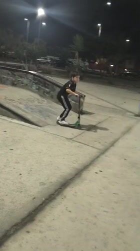 Youth rides scooter at nighttime skate park in Arica