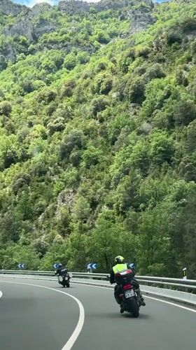 Motorcyclists navigate winding mountain road in Campo, Spain