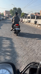 Morning street traffic and a security presence in Kalisampurno