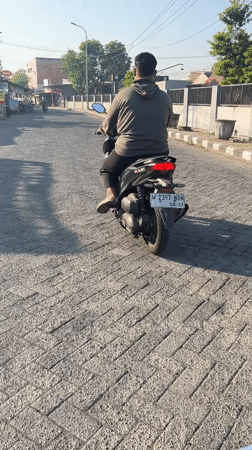Morning street traffic and a security presence in Kalisampurno