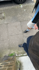 Couple takes selfies during London sidewalk stroll