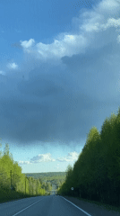 Vehicle travels rural road through trees near Chaikovsky, Russia