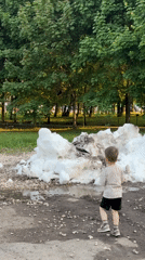 Boy stands near melting snow pile in Moscow