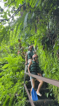 Two equipped individuals descend stairs in Payangan, Indonesia