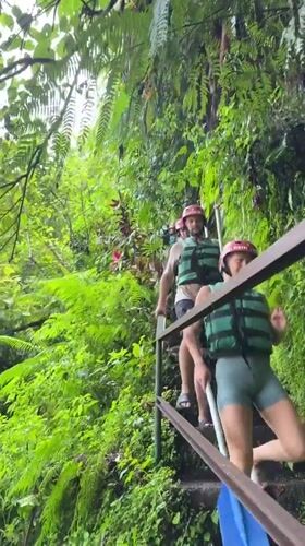 Two equipped individuals descend stairs in Payangan, Indonesia