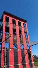 Two climbers scale striped wooden structure in Varna