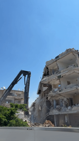 High-reach excavator dismantles multi-story building on Tel Aviv coast