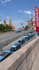Blue buses gather on Red Square with Victory flag