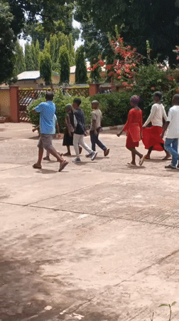 Children walk in synchronized formation in Nigerian community