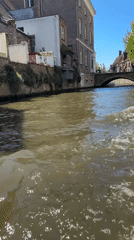 Canal boat tour carries young passenger through sunny Bruges
