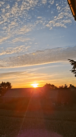 Rural sunrise, vivid sky, clouds scattered across the horizon