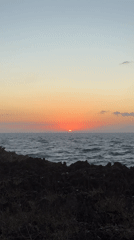 Tourists capture sunset and crashing waves at Kuta Selatan coastline