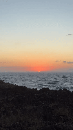 Tourists capture sunset and crashing waves at Kuta Selatan coastline