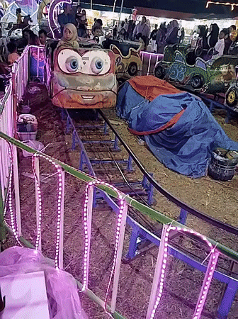 Community carnival night in Tasikmadu with rides, games, and coloring stalls