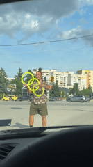 Street performer juggles yellow rings at Sofia crosswalk