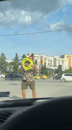 Street performer juggles yellow rings at Sofia crosswalk