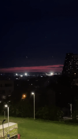 Belgrade sunset illuminates construction cranes during evening twilight