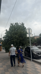 Pedestrians walk on checkered sidewalk in cloudy Tashkent