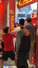 Nighttime street confrontation outside a Madrid shop