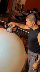 Sanding a large white sphere near Karaganda city administration