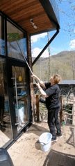 Woman cleaning windows captured on sunny morning in Medoveevka