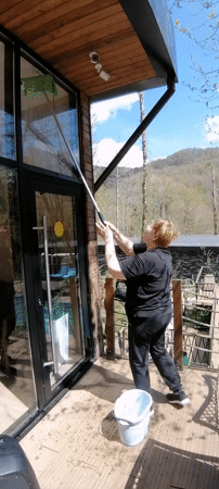 Woman cleaning windows captured on sunny morning in Medoveevka