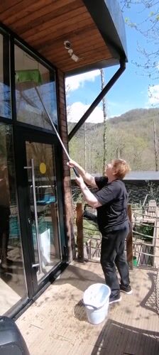 Woman cleaning windows captured on sunny morning in Medoveevka