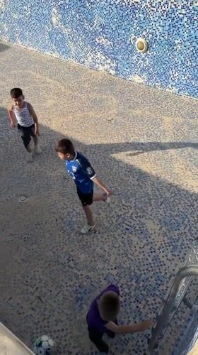Children play soccer in empty pool in Trebesin, Montenegro