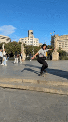 Woman performs skateboard ollie trick in Barcelona plaza