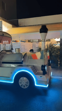 Tourist train and quadricycle share Gatteo's summer night streets