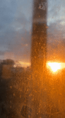 Orange sunrise viewed through dirty window in Zhilevo, Russia