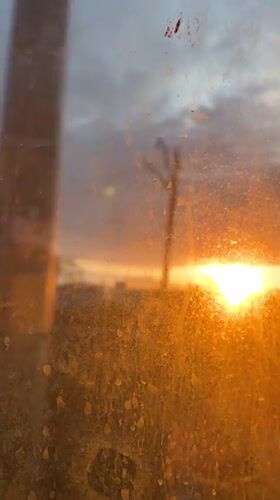 Orange sunrise viewed through dirty window in Zhilevo, Russia