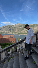 Young couple photographs scenic Bay of Kotor from Montenegro balcony