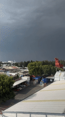 Dark storm cloud approaches Puebla town rooftops